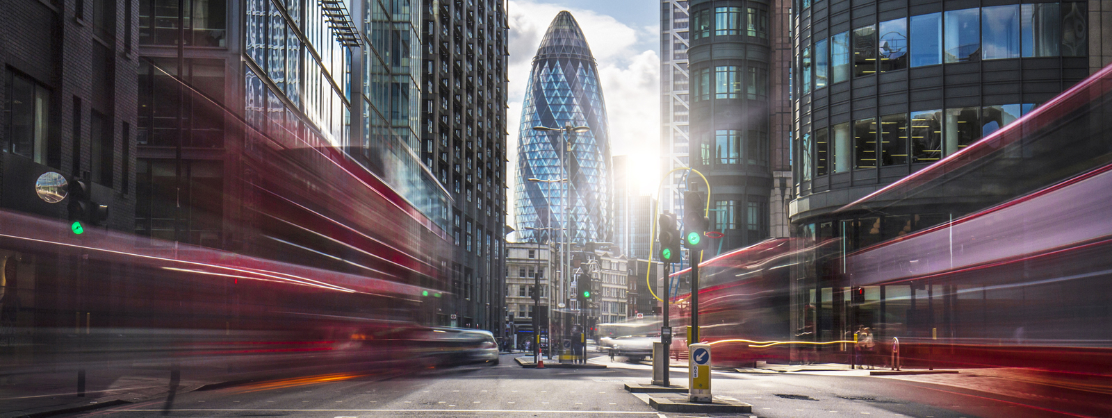 High-Speed photography of double decker buses and the Gherkin building in the background.
